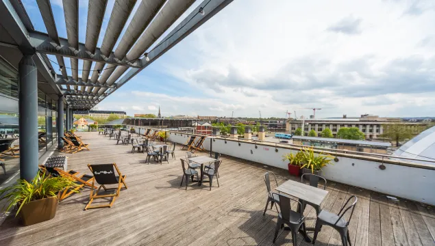 A view of the outside terrace with deck chairs and tables placed throughout