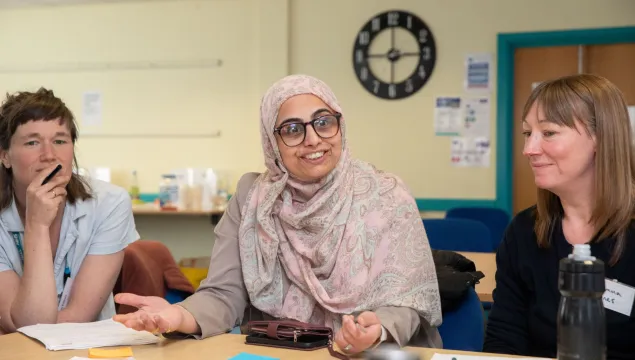 Three women at a table with post it notes and pens